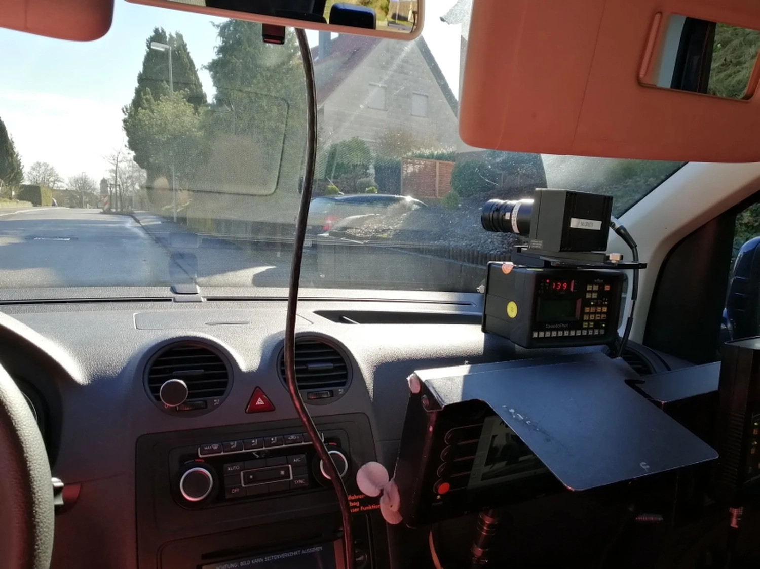 Radarrent GmbH – Verkehrsüberwachung – Innenraum eines Auto-Armaturenbretts mit einem neben dem Beifahrersitz montierten Radar- oder Geschwindigkeitskameragerät